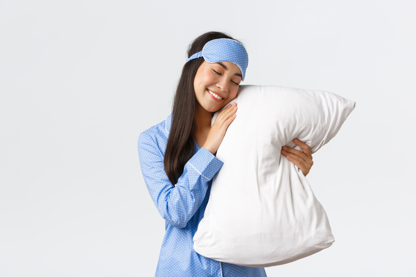 Chica abrazada a la almohada limpia